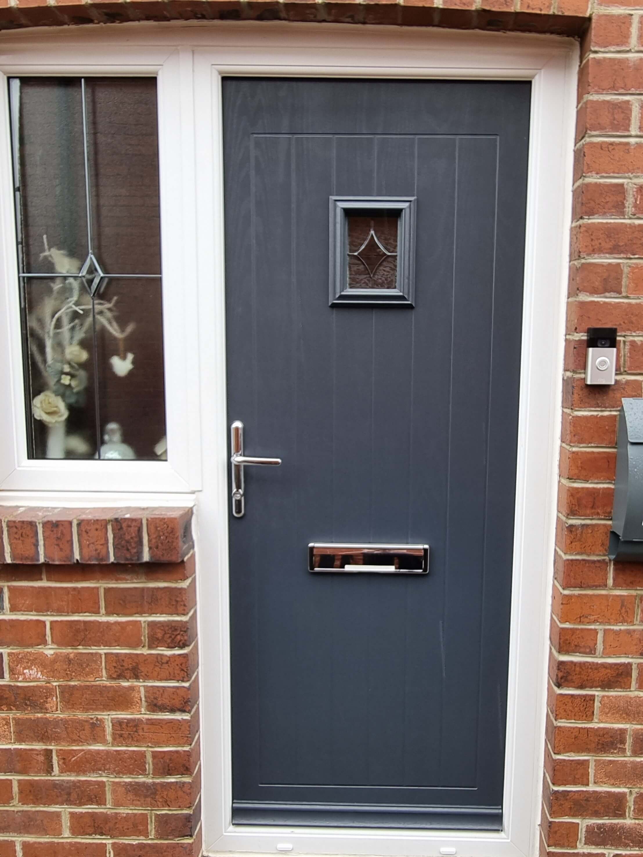 Grey composite door repaired in Leeds with chrome handles and chrome letterbox
